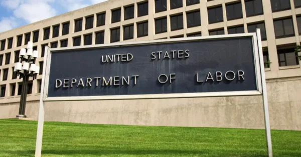 United States Department of Labor Building in Washington DC. The building is in the background and a black sign shows US Dept. of Labor. 