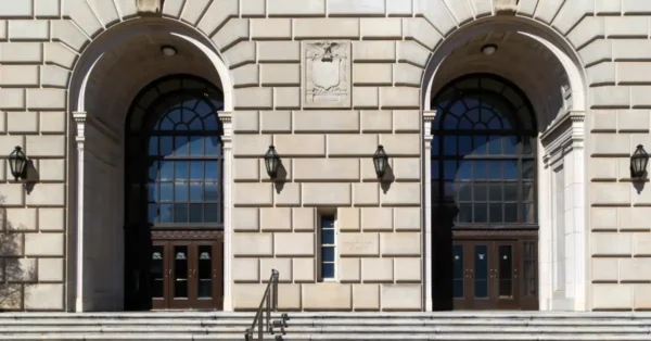 Close up image of the Internal Revenue Building showing two arched doors with a staircase leading up to the doors.