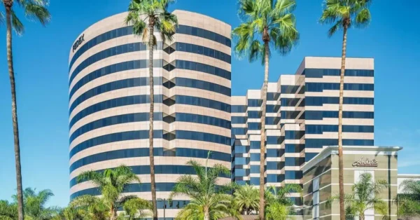 Picture of JLK Rosenberger's Irvine California office building. There are palm trees in the foreground.