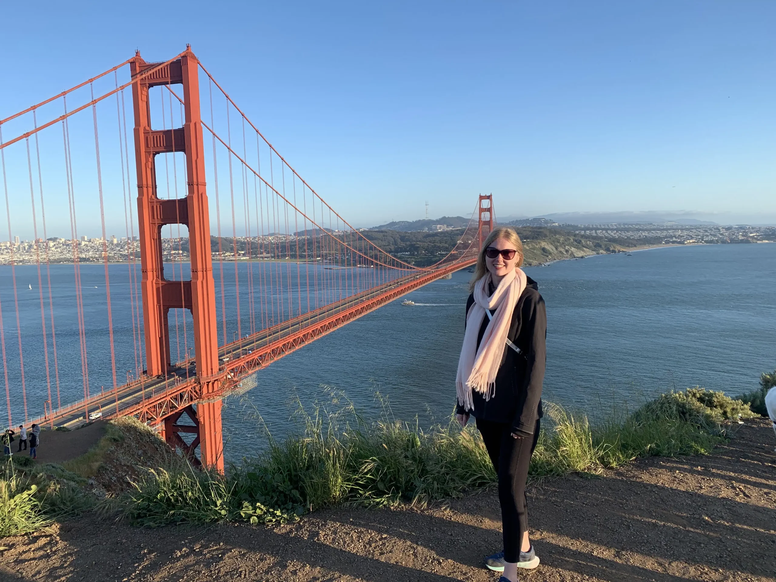Antonia is standing with a view of the Golden Gate Bridge in the background during her travels as part of her secondment.